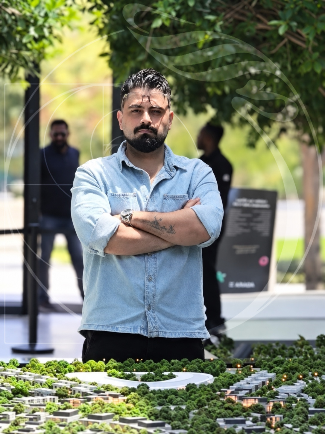 Doulama Ghassan Orije standing behind an architectural community model